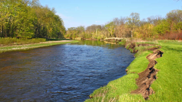 Serene river flowing through lush green landscape