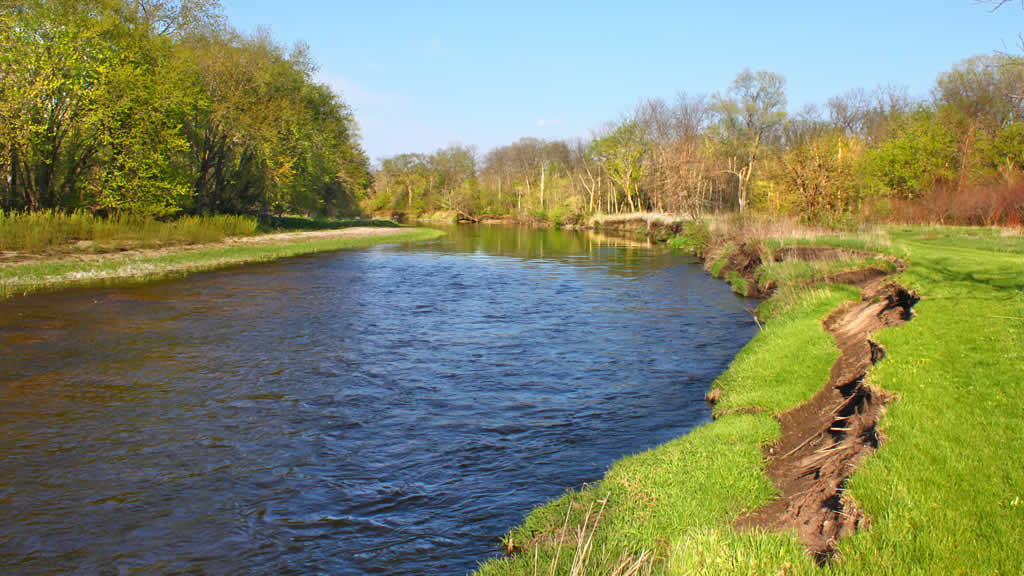 Serene river flowing through lush green landscape