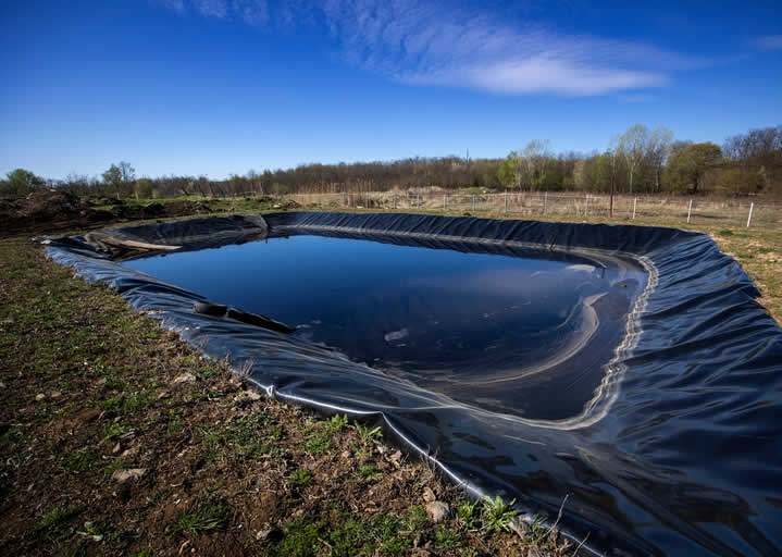 Large outdoor man-made water retention pond in daylight